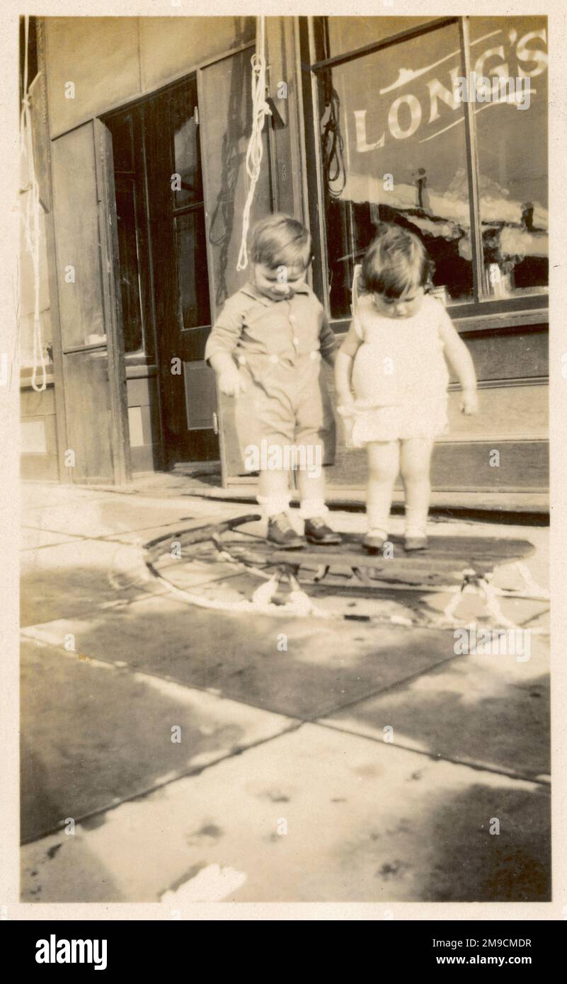 Deux enfants américains jouent sur leur toboggan à l'extérieur du long's Cafe. Banque D'Images