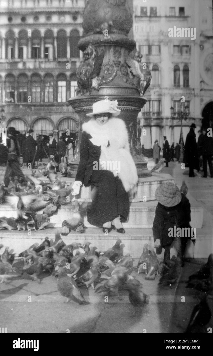 Une femme élégante est assise avec des pigeons à Venise, en Italie. Banque D'Images