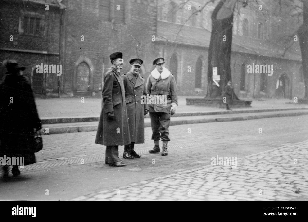 Trois officiers de l'armée britannique dans une ville non identifiée en Allemagne vers la fin de la Seconde Guerre mondiale, photographiés dans la rue près de l'hôtel de ville. Banque D'Images