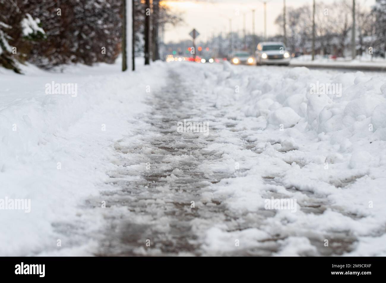 Route d'hiver avec fonte de neige salée. Gros plan du trottoir avec de la neige fondante le jour de la neige. Mise au point sélective Banque D'Images