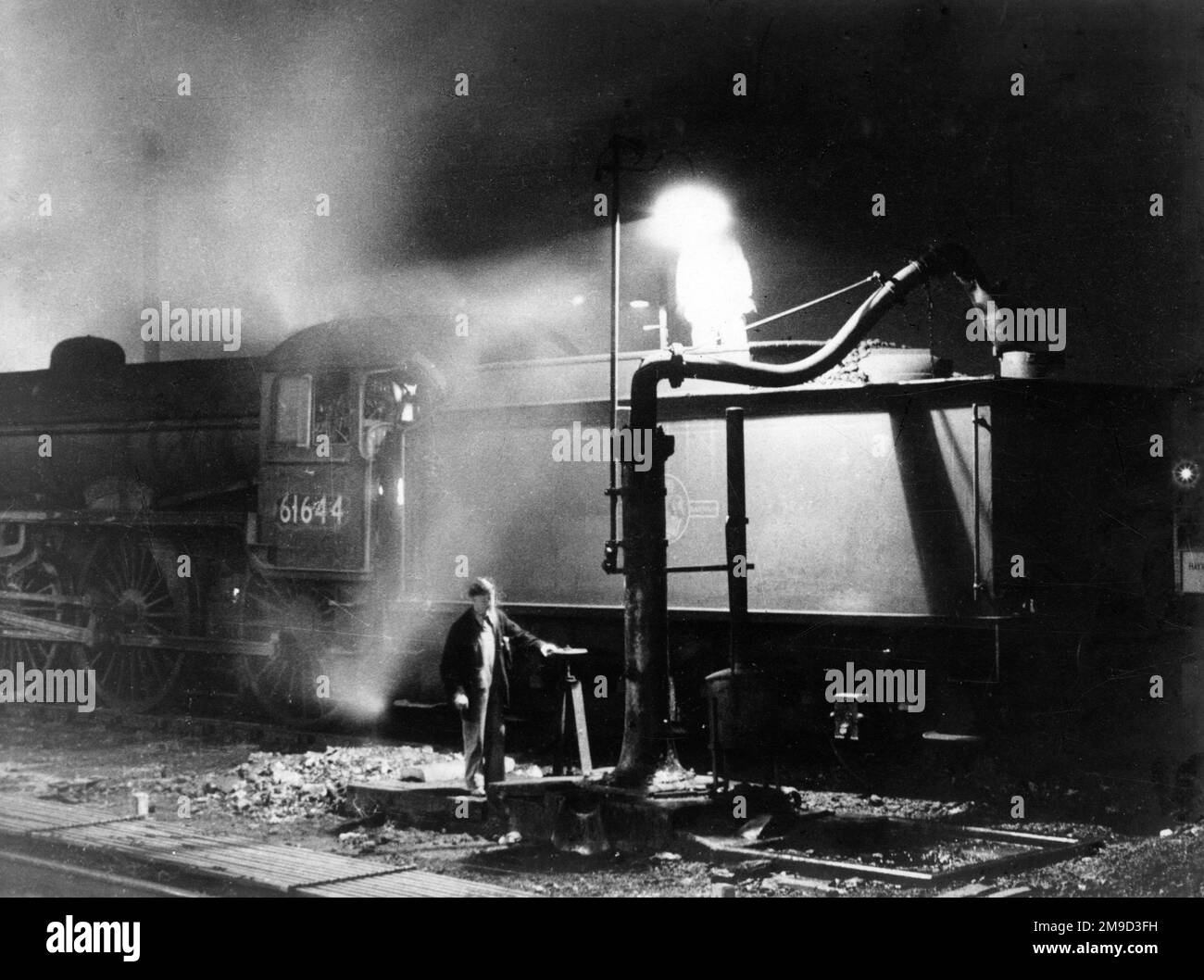 Homme travaillant sur le côté d'un train à vapeur. Banque D'Images