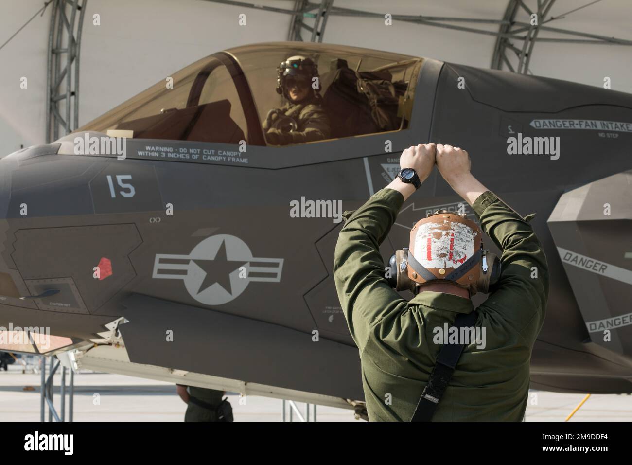 ÉTATS-UNIS Le Cpl Shane White, mécanicien d'aéronefs à voilure fixe du corps maritime, à droite, envoie un signal au Capt Evan Staton, pilote de chasse, tous deux avec l'escadron d'attaque de chasseurs maritimes (AFMV) 242, à la station aérienne du corps maritime Iwakuni (Japon), 17 mai 2022. Après avoir réussi l'exercice RED FLAG 22-1, VMFA-242 a atteint la pleine capacité opérationnelle, leur permettant d'exécuter une série complète de missions en tant qu'escadron F-35B Lightning II. Banque D'Images