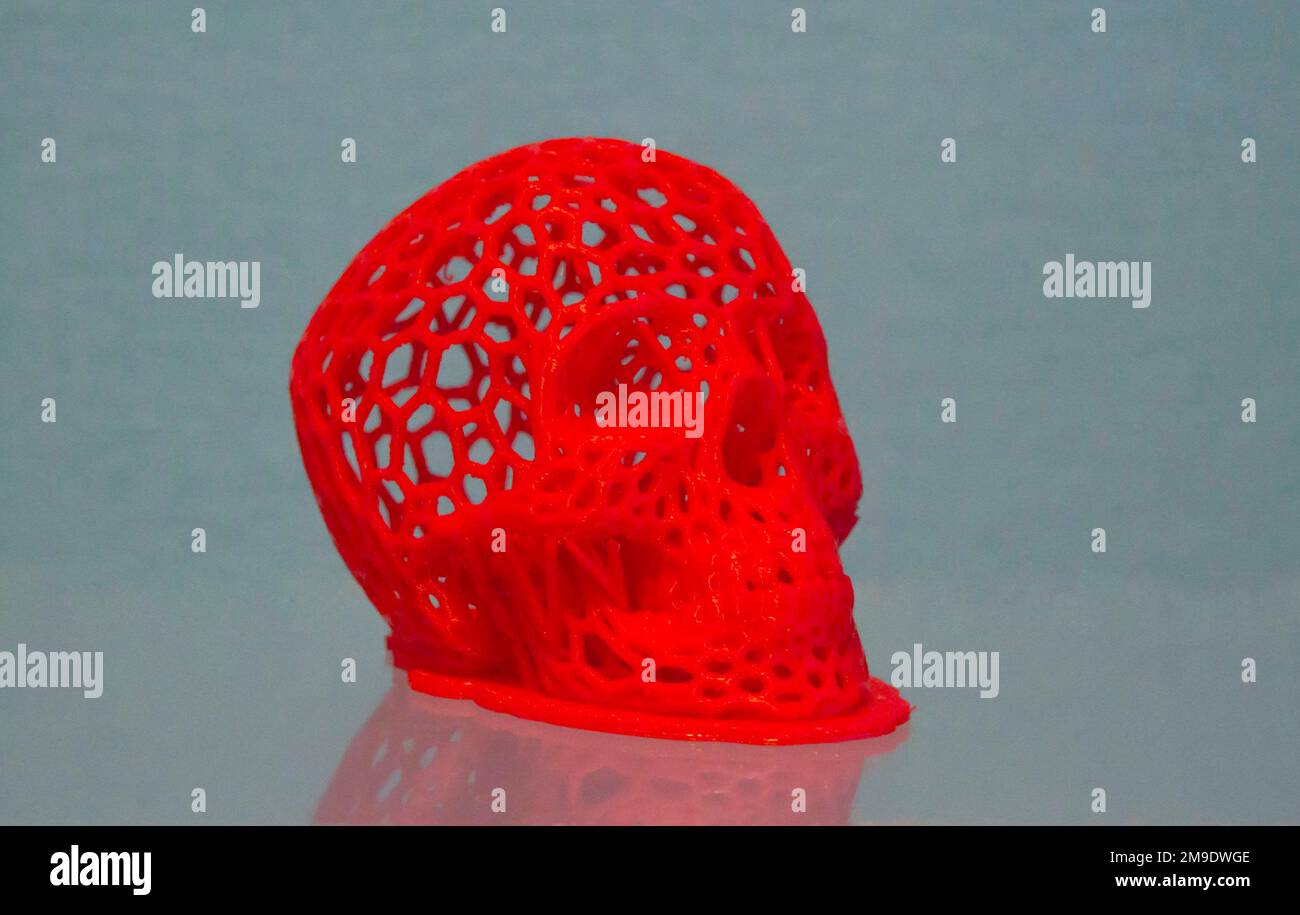 3D prototype de crâne humain imprimé imprimé en plastique rouge gros plan. Banque D'Images