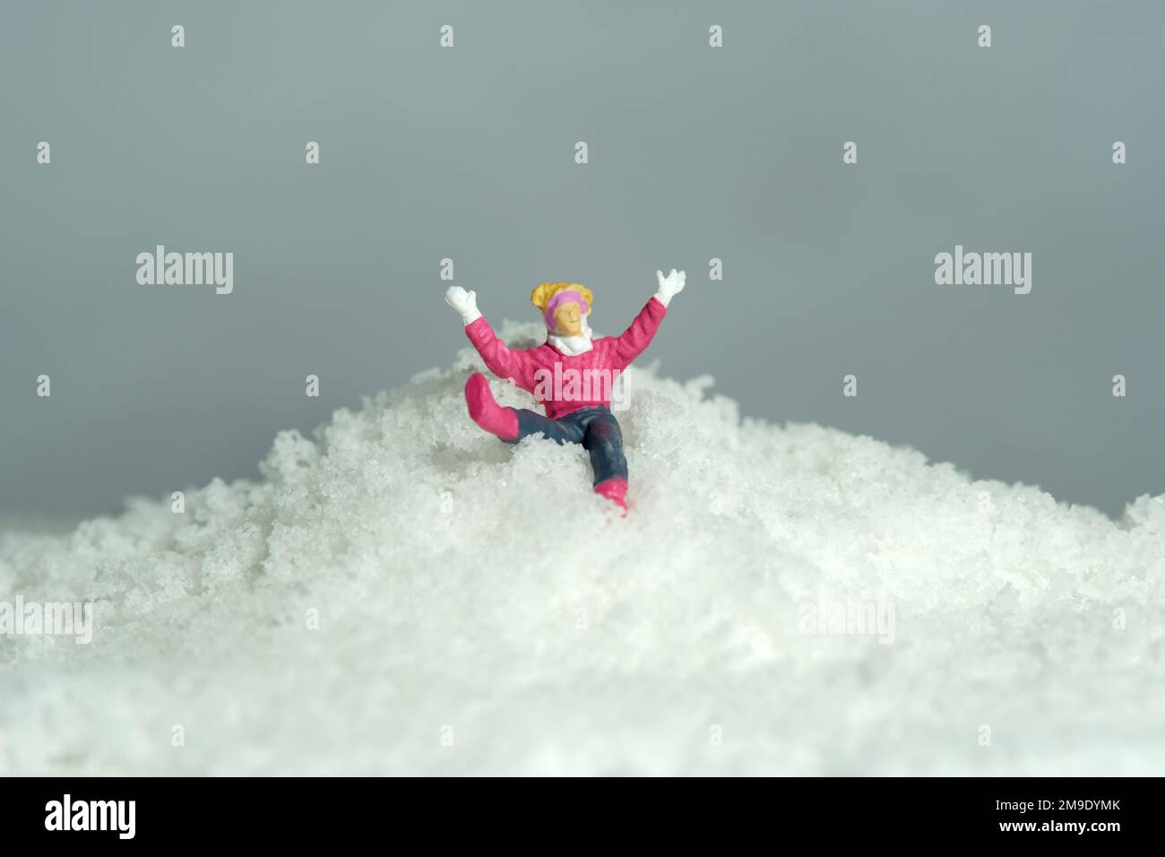 Photographie miniature de personnage de jouet de personnes. Mountain Climb accident sport. Une femme grimpeur de neige tombant dans la montagne enneigée. Photo d'image Banque D'Images