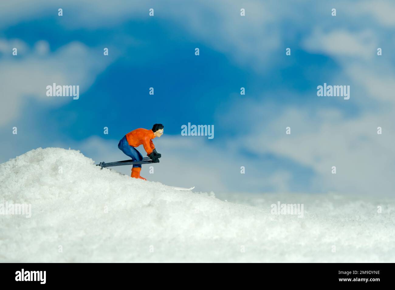 Photographie miniature de personnage de jouet de personnes. Sports d'hiver. Un coureur de ski alpin descend du sommet de la colline. Photo d'image Banque D'Images