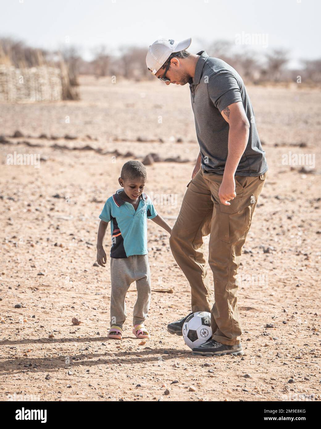 A ÉTATS-UNIS Un soldat du bataillon des affaires civiles de 404th, affecté au groupe expéditionnaire aérien de 409th, joue au soccer avec un enfant du village d'Attimick, au Niger, lors d'un engagement entre son équipe et le chef du village, 18 mai 2022. Ces engagements servent d'outil aux affaires civiles pour recueillir des informations et établir des rapports au sein de la communauté locale, renforçant ainsi un partenariat de longue date entre les États-Unis et les citoyens du Niger. Banque D'Images