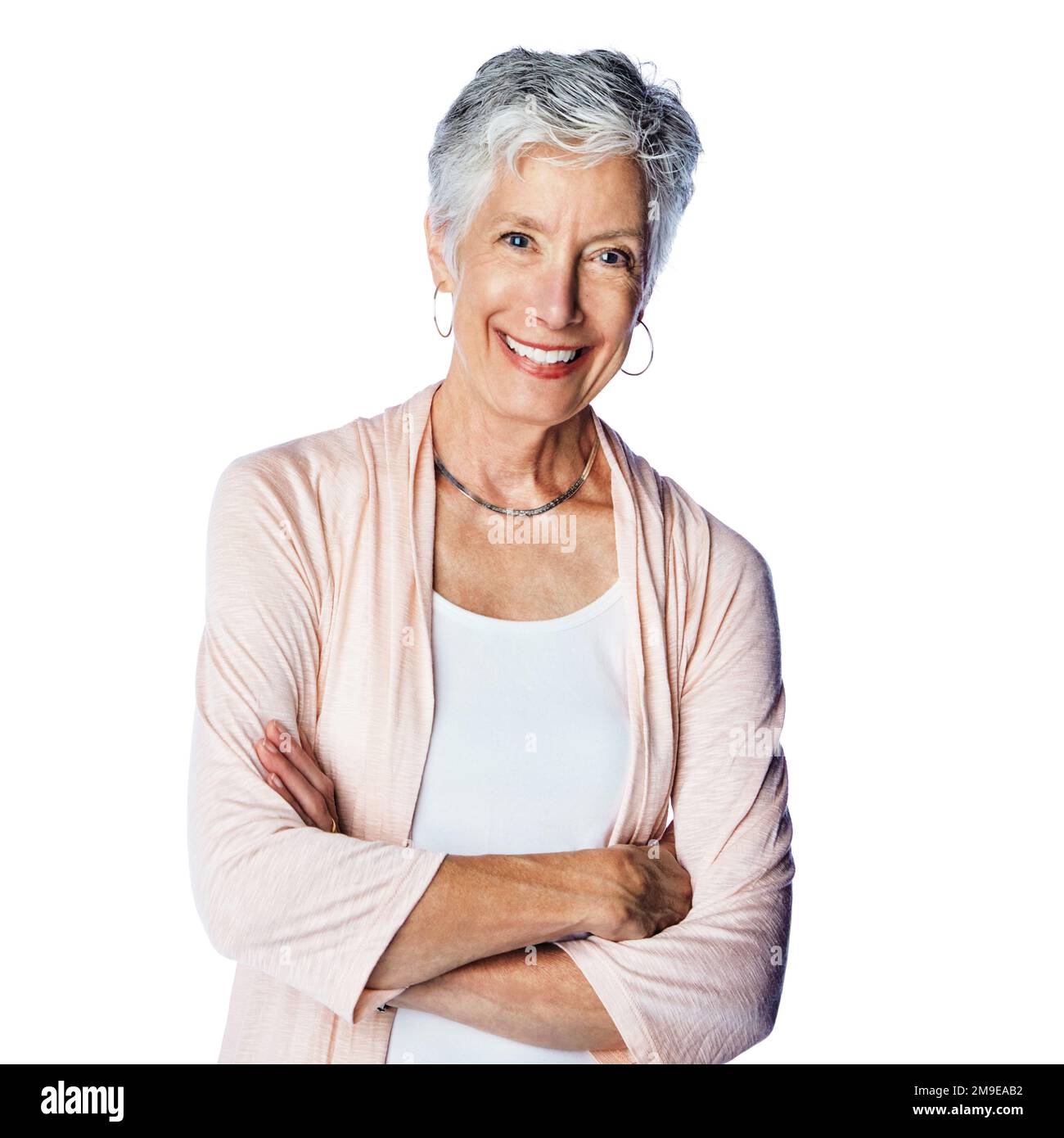 Femme âgée, portrait de studio et bras croisés avec le sourire, le bonheur et la mise au point sur fond blanc. Vieille femme isolée, retraite et beauté des personnes âgées Banque D'Images