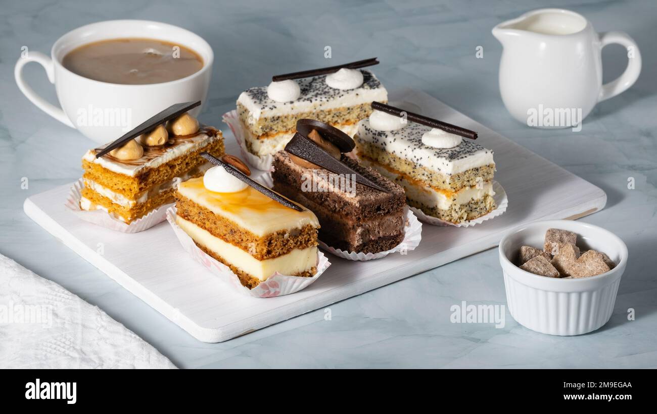 Un ensemble de délicieux gâteaux et café sur une table légère Banque D'Images