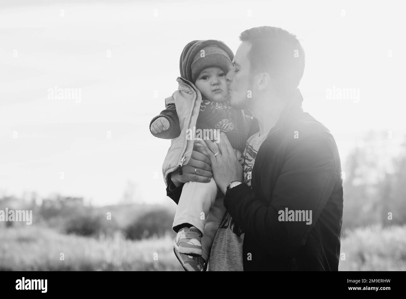 Un père caucasien embrasse son petit garçon fils dans la nature Banque D'Images