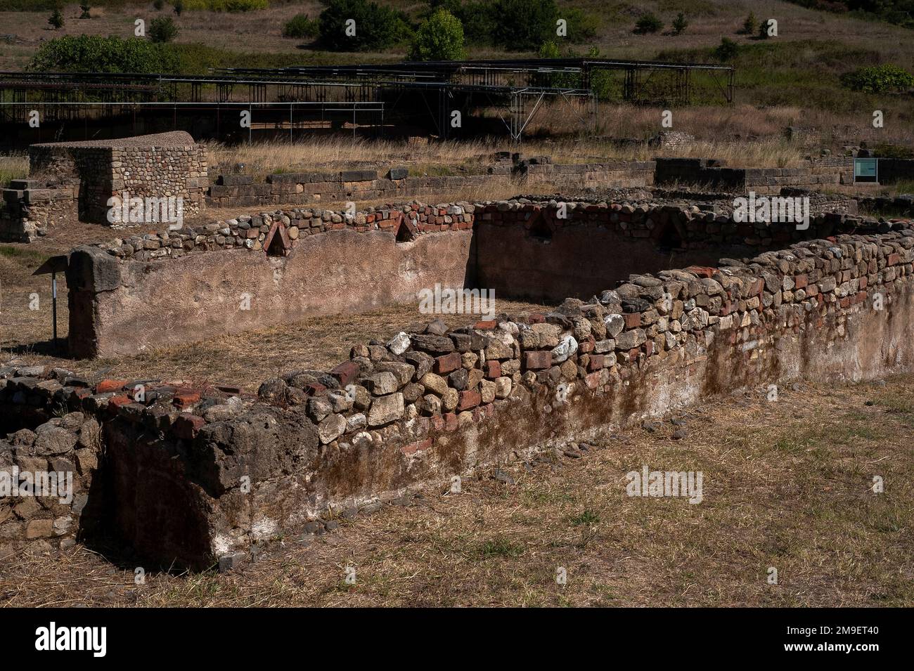 Niches Columbaria en brique à pignons, de type colomvecote, pour la crémation de bas statut, les interments bordent les murs intérieurs d'une nécropole dans l'ancienne Velia à Marina di Ascea, Campanie, dans le sud de l'Italie. Au-delà, les toits plats modernes protègent les vestiges excavés d'une insula, un immeuble probablement construit à l'époque hellénistique, puis restauré par les Romains. Banque D'Images