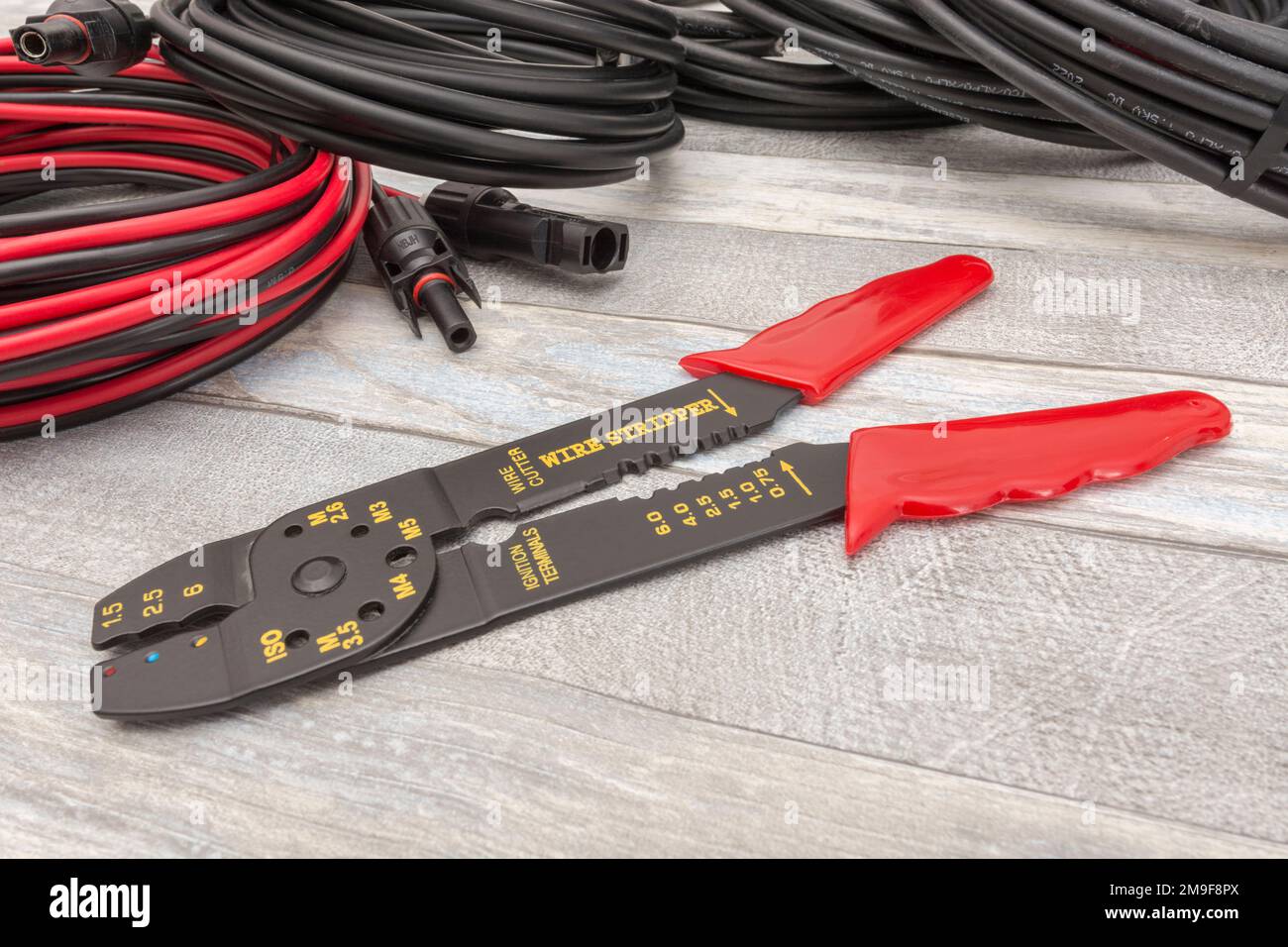 Plan de travail de pince à dénuder et coupe-fil de marque chinoise pour 26-10AWG fils (voir Notes) avec câbles de connecteur solaire spiralés et MC4 prises femelles. Banque D'Images