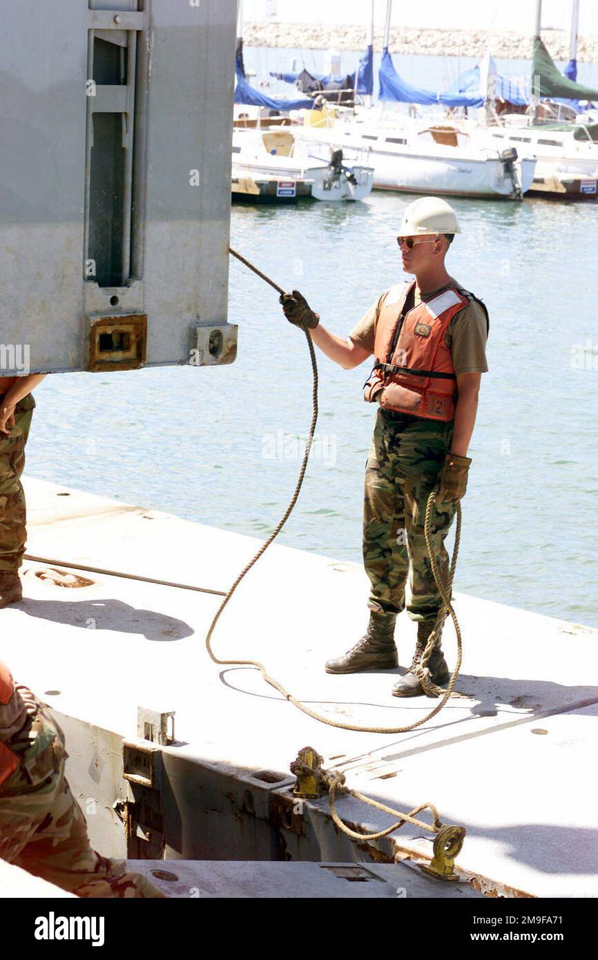 Un soldat de l'armée américaine (États-Unis) affecté à la compagnie de transport 331st, montres comme un morceau de la jetée de Trident est abaissé dans l'eau pendant l'exercice TURBO PATRIOT, un exercice de logistique mixte sur-le-rivage (JLOTS), à Camp Pendleton, Californie (CA). Base: Corps de marine base Camp Pendleton État: Californie (CA) pays: Etats-Unis d'Amérique (USA) Banque D'Images