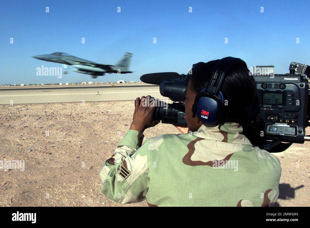 LUELLA Wilson, AVIATEUR PRINCIPAL DE LA US Air Force, un vidéaste du 1st combat Camera Squadron, à la base aérienne de Charleston, en Caroline du Sud, effectue des enregistrements vidéo sur un avion F-15 Eagle qui part de la base aérienne de Prince Sultan, en Arabie Saoudite. SRA Wilson fait partie de l'équipe de la caméra de combat qui a été déployée pour documenter les opérations de l'aile expéditionnaire aérienne de 363rd qui applique la zone d'exclusion aérienne et de non-déplacement dans le sud de l'Iraq afin de protéger et de se défendre contre l'agression iraquienne à l'appui de l'opération SOUTHERN WATCH. Objet opération/série : BASE DE SURVEILLANCE SUD : base aérienne de Prince Sultan pays : Arabie saoudite (SAU) Banque D'Images