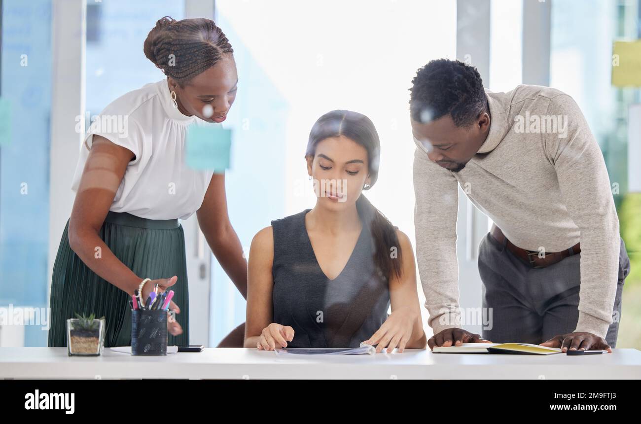 Travailler sur un autre grand plan. un groupe d'hommes d'affaires qui passent par la paperasse dans un bureau. Banque D'Images