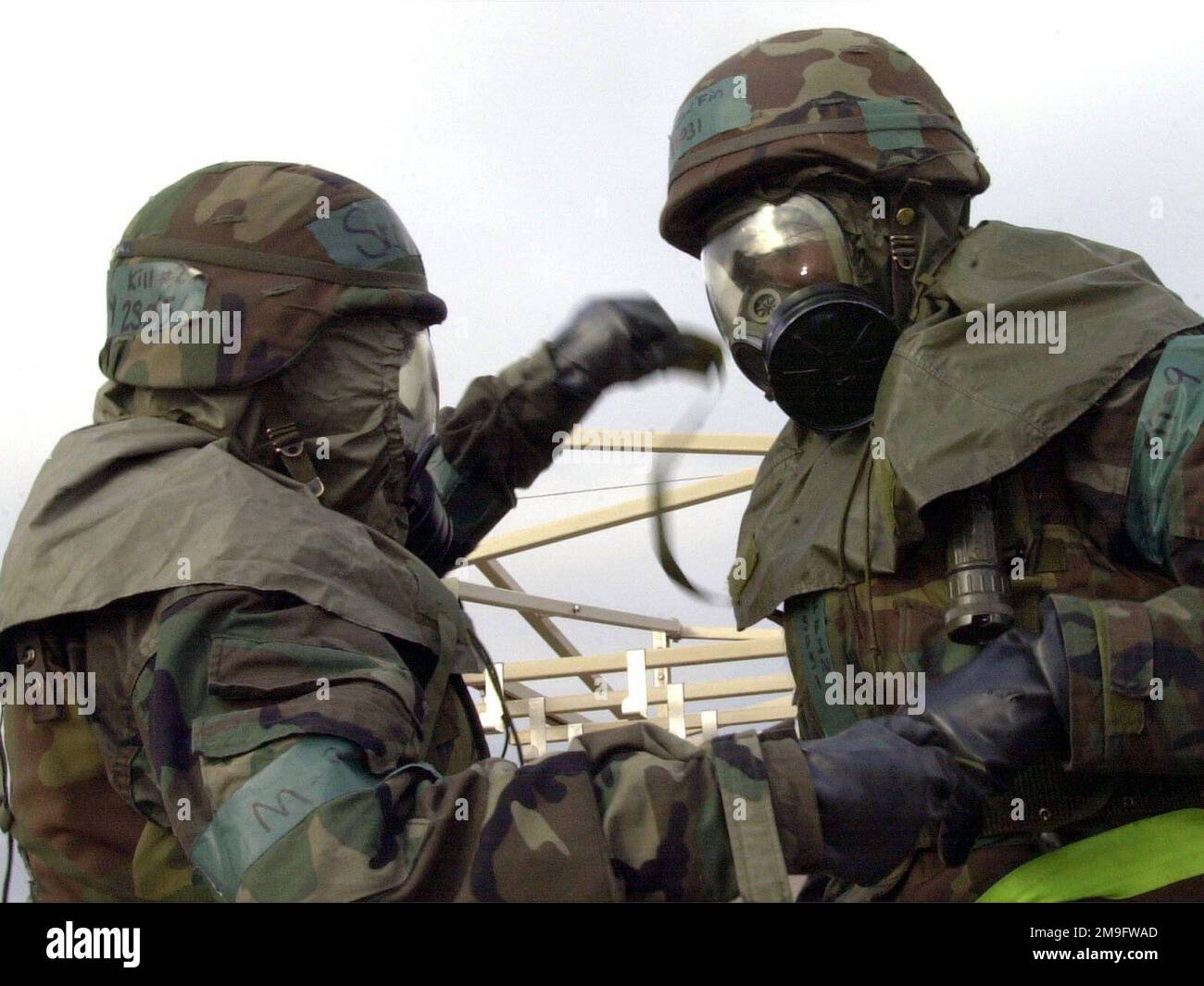 LES aviateurs DE la Force aérienne DES ÉTATS-UNIS de l'escadron de communications 8th, à la base aérienne de Kunsan, en République de Corée, s'aident mutuellement à retirer le capot/masque et les gants de leur équipement de niveau 4 (MOPP-4) de la posture de protection orientée mission, à l'intérieur de la zone de contrôle des contaminants, pendant l'inspection opérationnelle (ORI). Les 8th membres du personnel des ailes de chasseurs sont évalués sur leurs capacités en temps de guerre pendant leur ORI. Base: Kunsan Air base pays: République de Corée (KOR) Banque D'Images