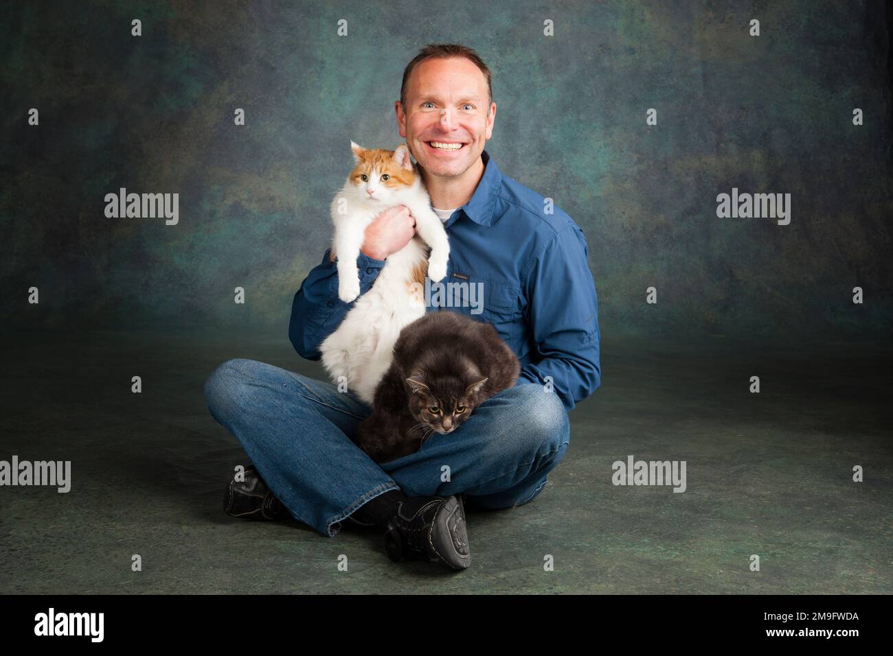 Studio portrait of smiling man avec deux chats Banque D'Images