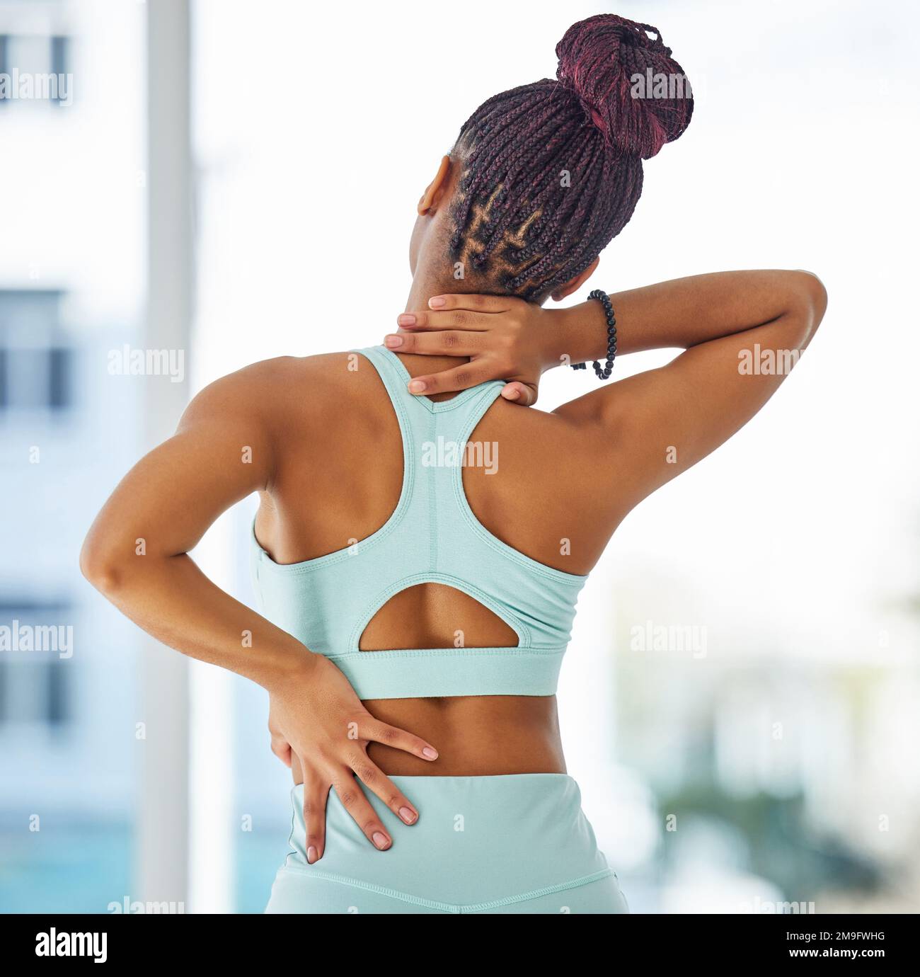 Ma douleur au dos affecte maintenant mon cou. une femme méconnaissable debout seule dans un studio de yoga et souffrant de douleurs au dos et au cou. Banque D'Images