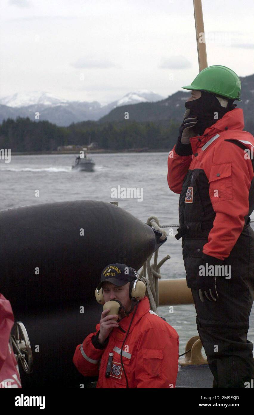 US Coast Guard Machinery Technician Third Class radios la position des bateaux de patrouille qui escortent son bateau la garde côtière Cutter NUSHON, tandis que le technicien de machines troisième classe Duane tempêtes observe également la position des bateaux qui servent de gardes pendant l'exercice NORTHERN EDGE 2001 à Ketchikan, Alaska. Northern Edge est le premier exercice d'entraînement conjoint de l'Alaska et englobe des troupes militaires de toute l'Amérique du Nord. L'exercice a lieu dans tout l'État de l'Alaska et il dure deux semaines. Objet opération/série: NORTHERN EDGE 2001 base: Naushon État: Alaska Banque D'Images