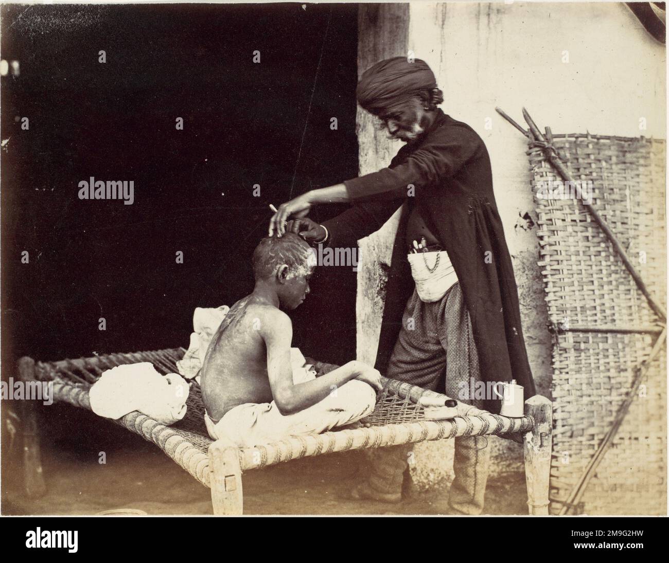 Willoughby Wallace Hooper - Indian Barber - 1860 - un homme âgé barber coupe les cheveux d'un jeune homme. Banque D'Images