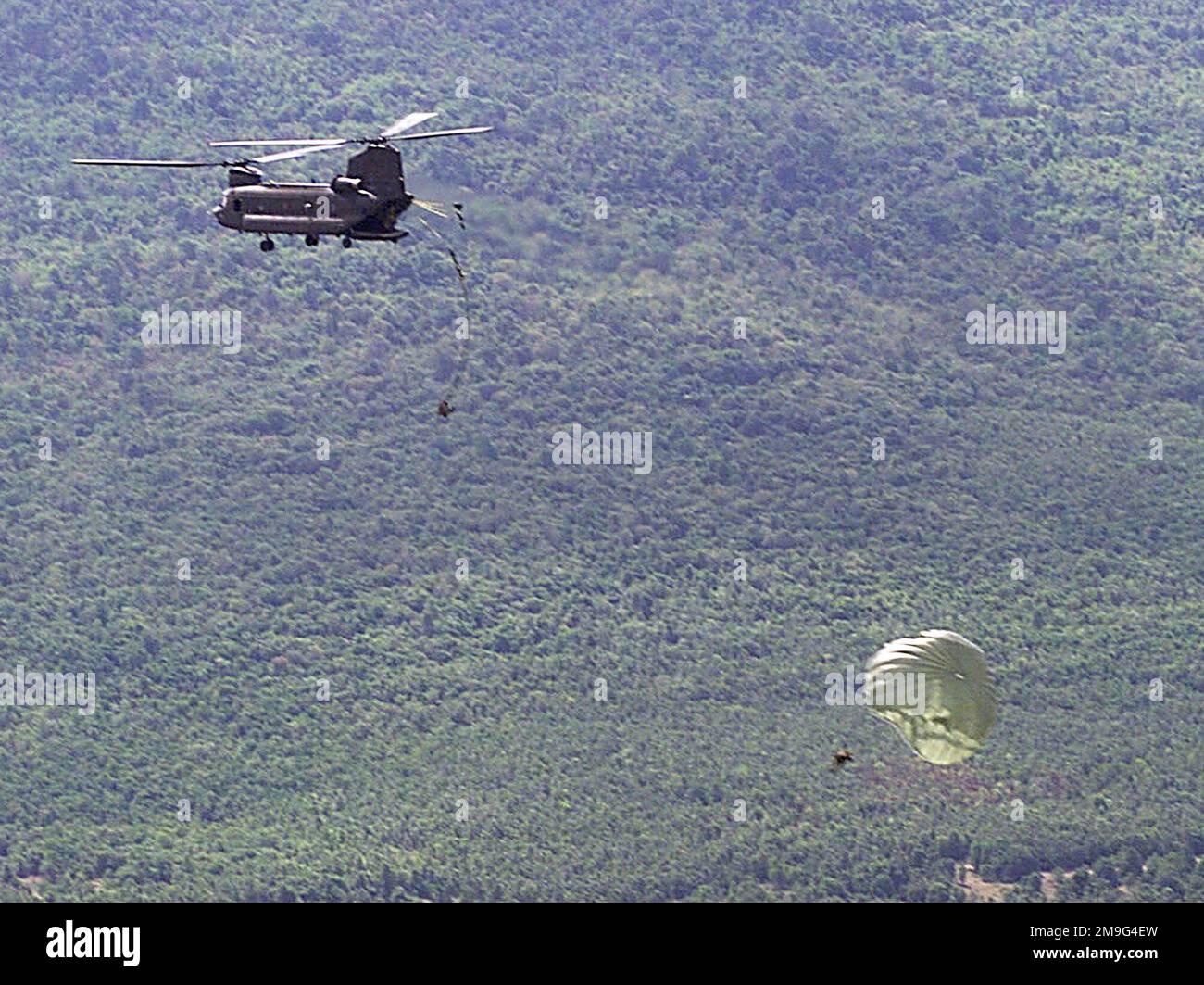 Le GROUPE DES forces spéciales DE 1st, le 2nd Bataillon, fort Lewis, Washington, et l'Armée royale thaïlandaise Airborne préforme un saut statique d'amitié pendant l'exercice COBRA GOLD 2001. COBRA GOLD est un exercice multilatéral qui comprend plus de 10 000 participants, 45 avions et 9 navires de l'armée américaine, des Forces armées royales thaïlandaises et des Forces armées singapouriennes. COBRA GOLD est le plus grand exercice militaire multilatéral tenu en Asie du Sud-est et vise à améliorer la capacité des forces armées à travailler ensemble pendant les opérations d'application de la paix et à mener une assistance humanitaire Banque D'Images