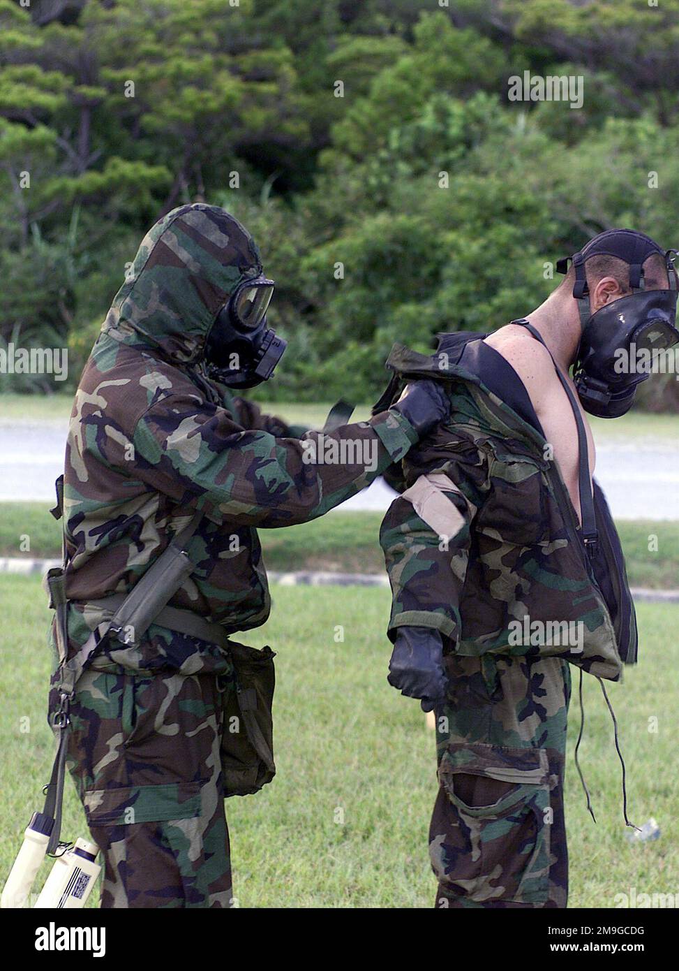 Tout en écoutant les instructions du membre de l'équipe de décontamination à ce poste de décontamination, les Marines de 3D RECON BN, 3D MAR DIV, Okinawa, Japon, se coupent en équipes d'amis et avec le masque de champ chimique-biologique M40 en place, Commencer à se dénuder l'un sur l'autre de leur équipement de niveau 4 (MOPP-4) de la posture de protection orientée mission. Le troisième Bataillon de reconversion a participé à un exercice d'entraînement qui teste la capacité de l'unité à réagir pendant les menaces nucléaires, biologiques et chimiques (NBC) du monde réel. Base : base du corps marin, Camp Hansen État : Okinawa pays : Japon (JPN) scène Major Co Banque D'Images