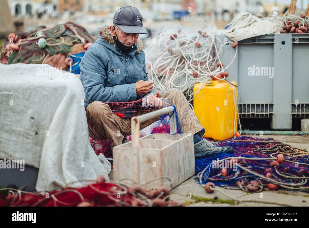 GALLIPOLI, ITAY-AVRIL 2022 : pêcheurs locaux fixant le filet de pêche sur le quai Banque D'Images