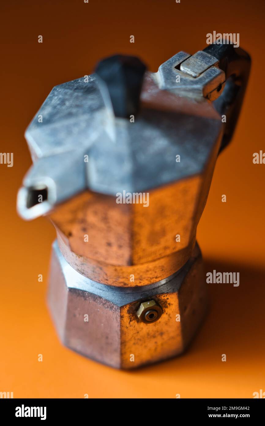 Gros plan d'une très vieille cafetière italienne sur de l'orange Banque D'Images