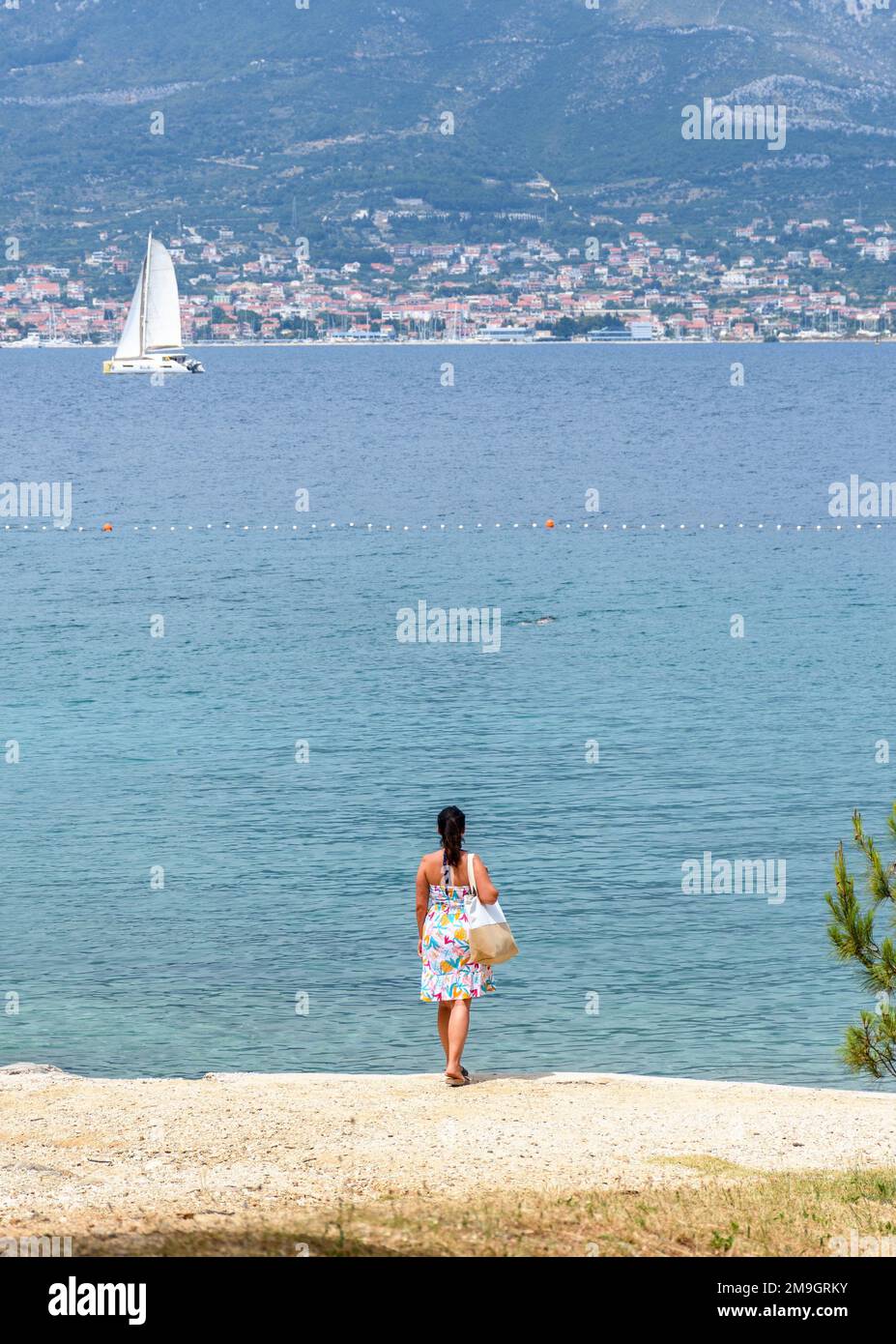 Une vue arrière d'une jeune femme se tenant sur la plage de Bene à Split, en Croatie Banque D'Images