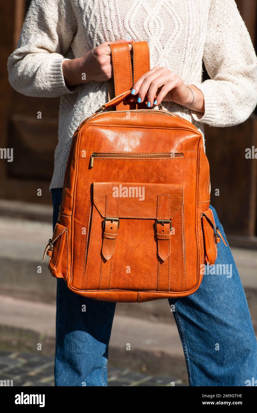 Femme avec un sac à dos en cuir orange avec un look ancien et rétro. Photo à  l'extérieur Photo Stock - Alamy