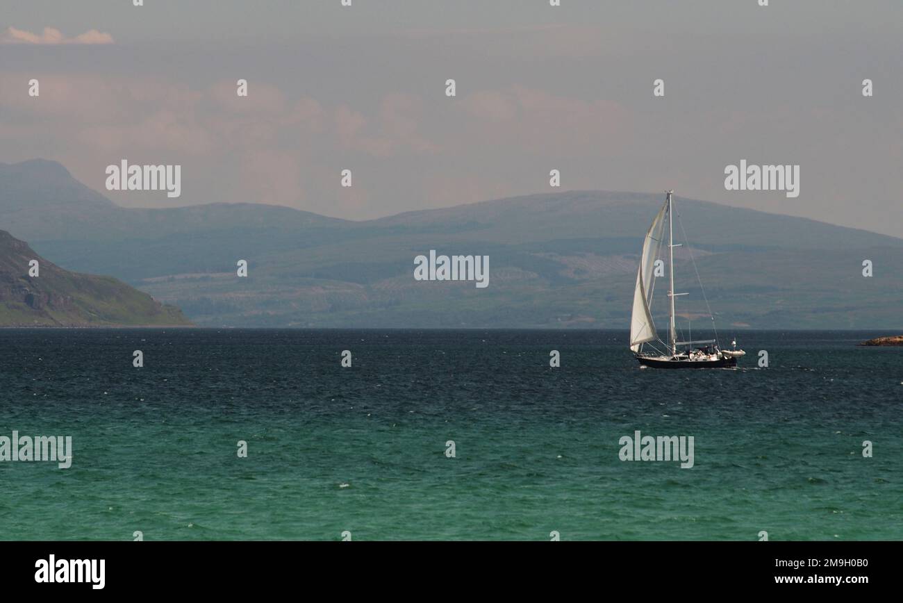 Un yacht naviguant dans le son d'Iona avec une mer d'aigue-marine et les collines de Mull en arrière-plan Banque D'Images