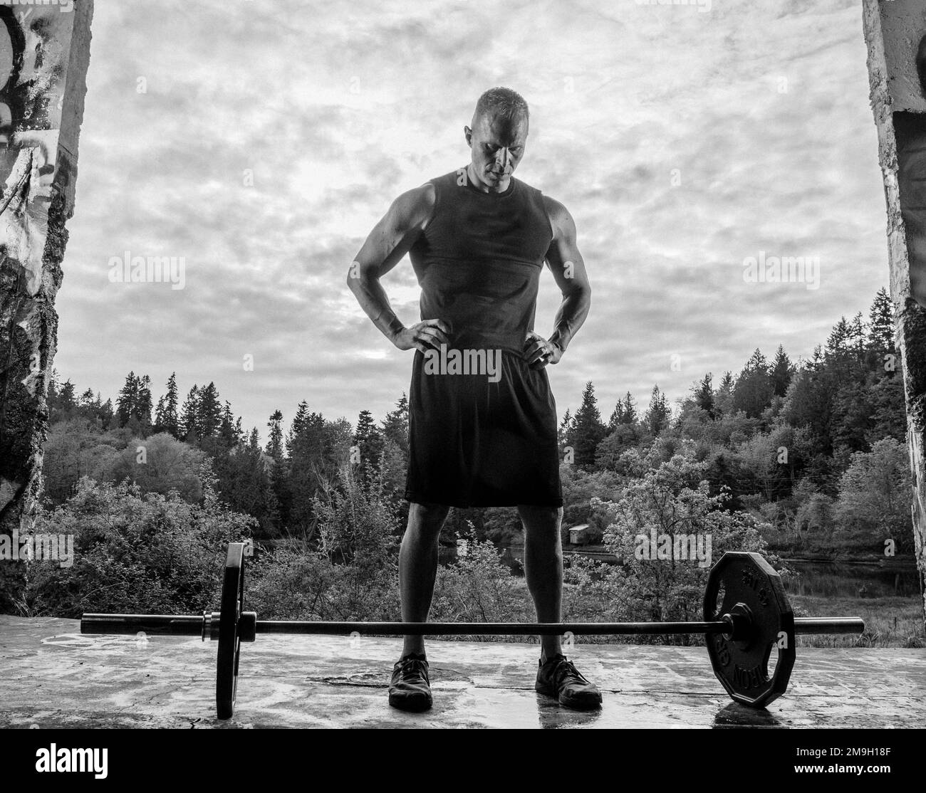 Photo en noir et blanc d'un sportif regardant la barbell, Bainbridge Island, Washington, États-Unis Banque D'Images