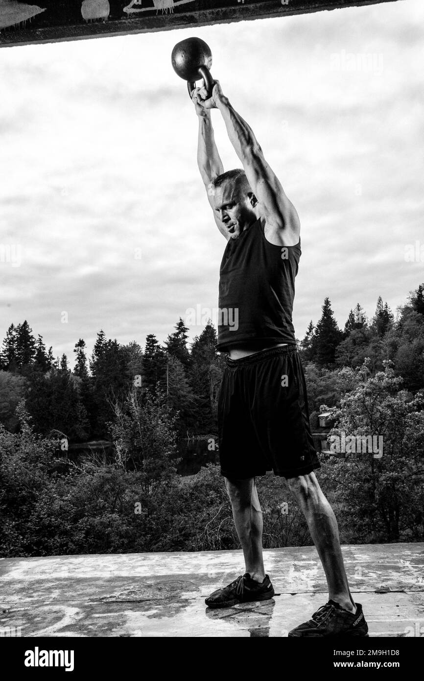 Homme s'entraînant à l'extérieur avec kettlebell, Bainbridge Island, Washington, États-Unis Banque D'Images