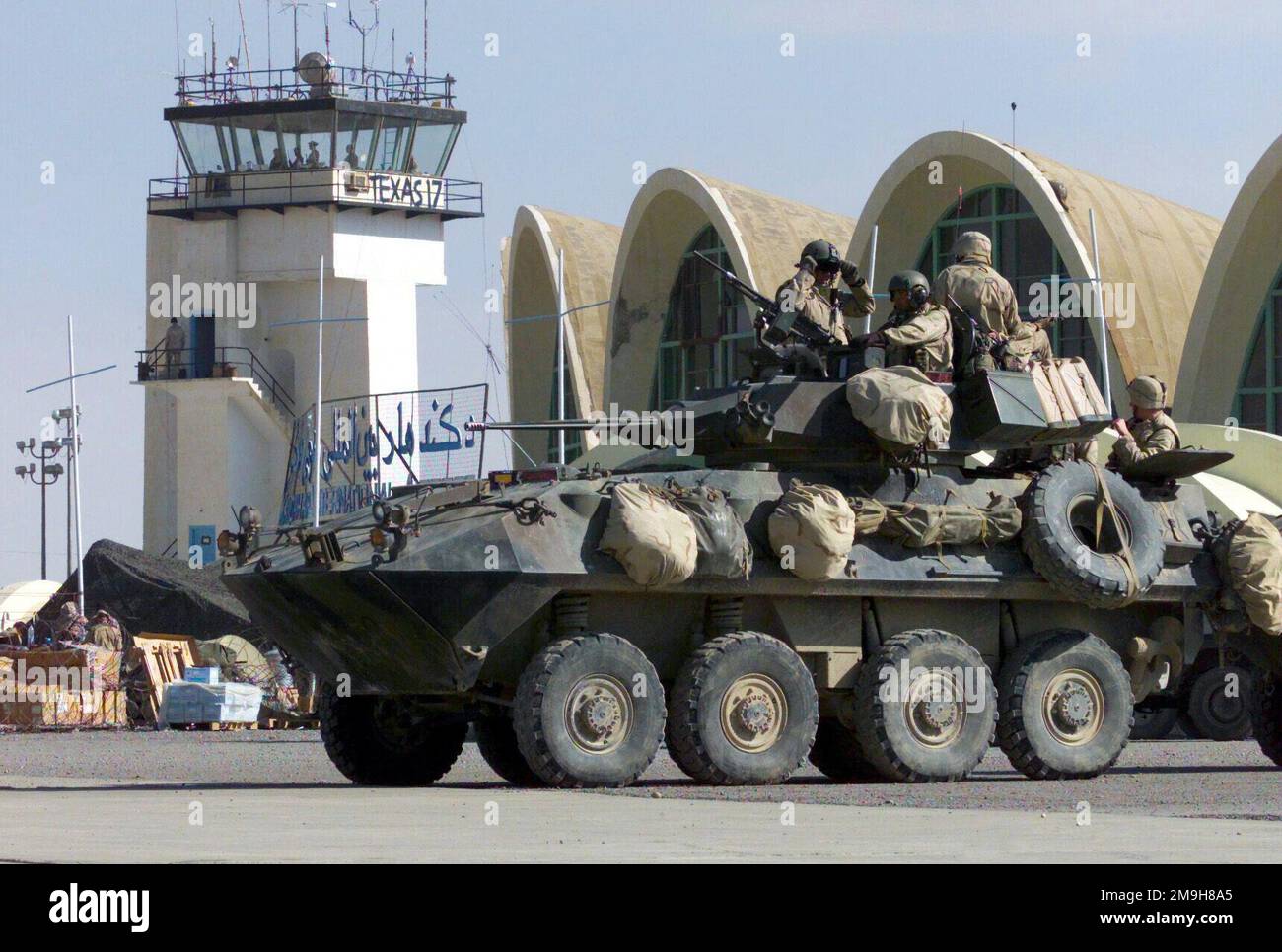 Marines de la Compagnie Alpha, 2D Light Armored Vehicle Company, attachée à l'équipe de débarquement du Bataillon 3/6, 26th Marine Expeditionary Unit (Special Operations Aétant capable), prépare leur véhicule d'armure léger (LAV)-25 pour effectuer une patrouille autour de l'aéroport international de Khandahar pendant L'OPÉRATION ENDURING FREEDOM. Un Marine à la prééquipement de la mitrailleuse de 7,62 mm au-dessus du canon à chaîne de M242 25mm dans la tourelle. En arrière-plan se trouve la tour de contrôle de Khandahar avec 'Texas 17,' le panneau d'appel Marine pour la région. Objet opération/série : BASE DE LIBERTÉ DURABLE : aéroport international de Kandahar pays : afghan Banque D'Images