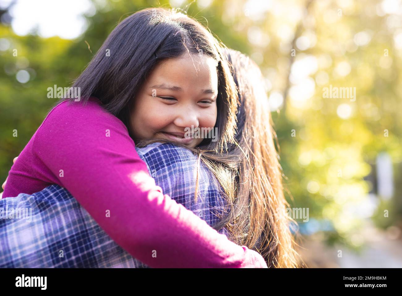 Bonne mère asiatique et fille s'embrassant dans le jardin Banque D'Images