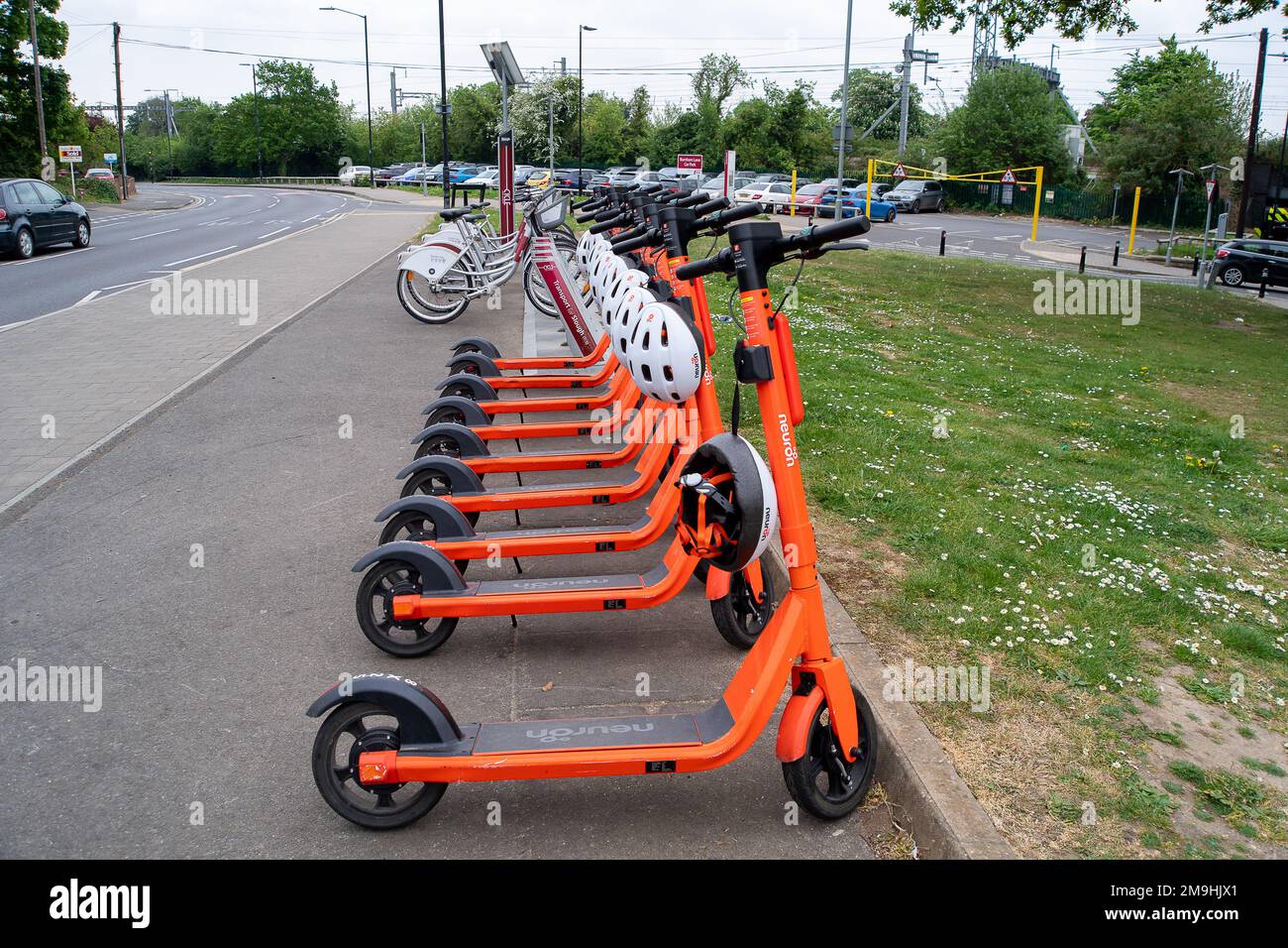 Slough, Berkshire, Royaume-Uni. 4th mai 2022. Scooters neurone e garés par Burnham Station. Le programme de location d'essai E-Scooter à Slough, géré par la société Neuron Mobility, a été prolongé de deux ans. Les trottinettes orange sont populaires, cependant, les e-trottinettes en général ont été critiquées car certains utilisateurs se mettent à la vitesse sur les trottoirs et les routes avec eux causant des accidents. Crédit : Maureen McLean/Alay Banque D'Images