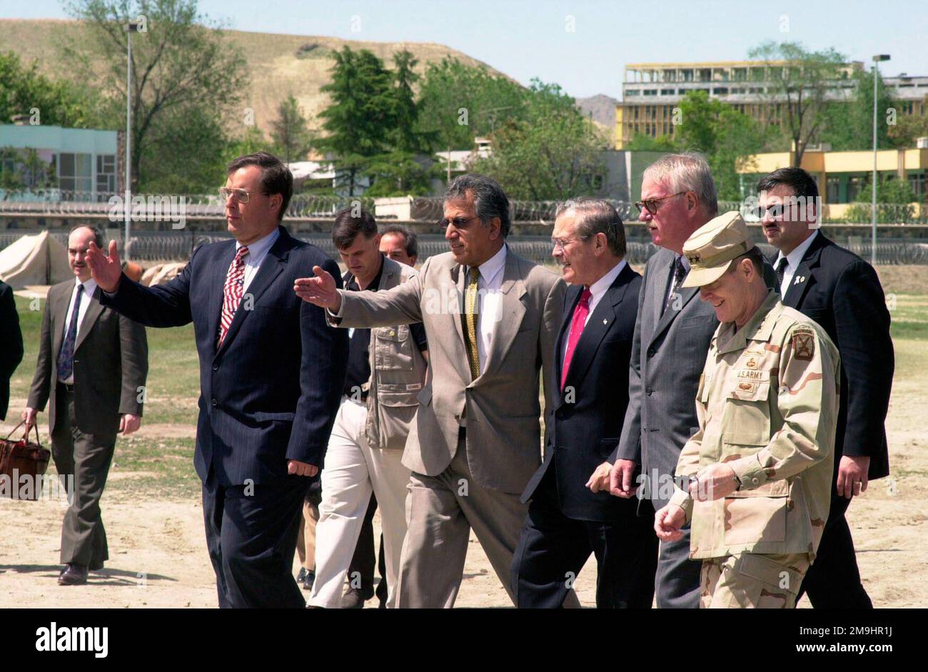 020427-M-0428C-003. [Complet] Légende de la scène : l'honorable Donald H. Rumsfeld (devant, troisième de droite), États-Unis Le secrétaire à la Défense, est escorté par M. David Sedney (devant, à gauche), chargé d'affaires, États-Unis Ambassade en Afghanistan; M. Zalmay M. Khalilzad (devant, deuxième à partir de la gauche), Envo du Président spécial pour l'Afghanistan; et l'honorable Robert P. Finn (à droite du secrétaire Rumsfeld), États-Unis Ambassadeur en Afghanistan, après son arrivée aux États-Unis Ambassade, à Kaboul, province de Kaboul, Afghanistan, on 27 avril, 2002, pour assister à une séance d'information sur l'entraînement en cours de l'Armée nationale afghane et de la partie Banque D'Images