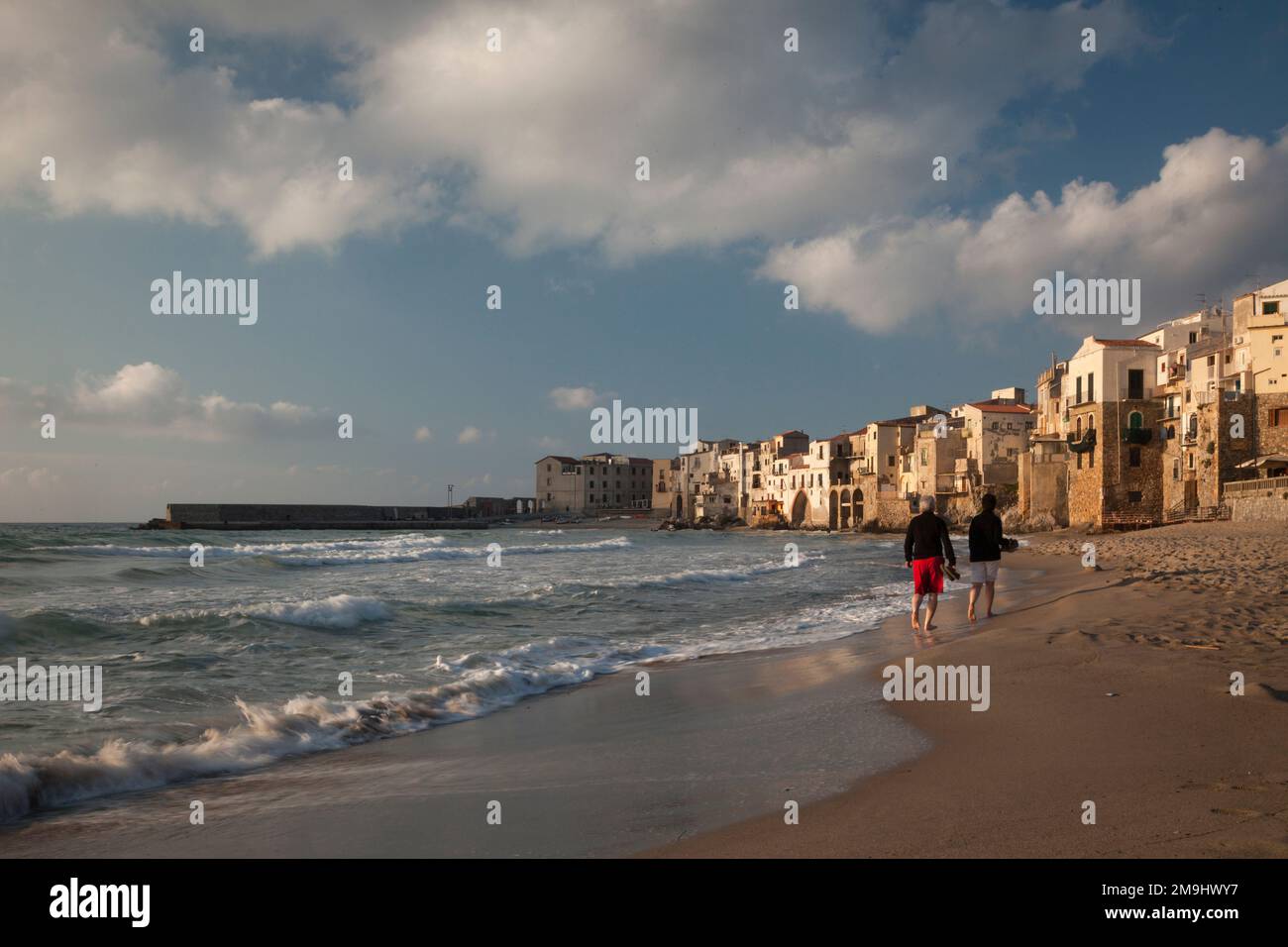 Couple se promenant sur la plage de Cefalù, Sicile Banque D'Images