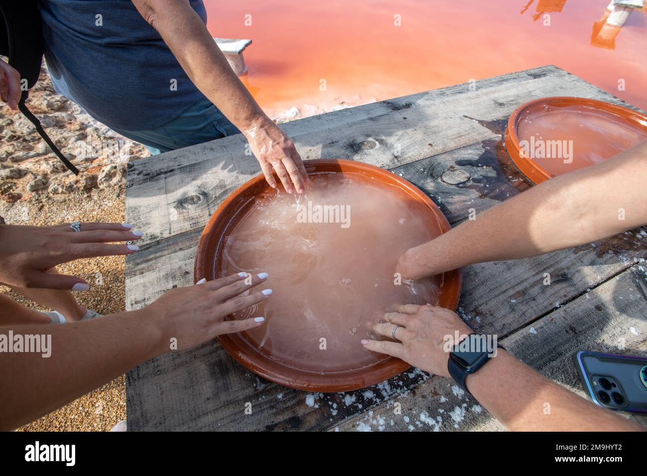 Les gens se retrouvant à l'eau salée curative des marais salants, Isla Cristina, Espagne Banque D'Images