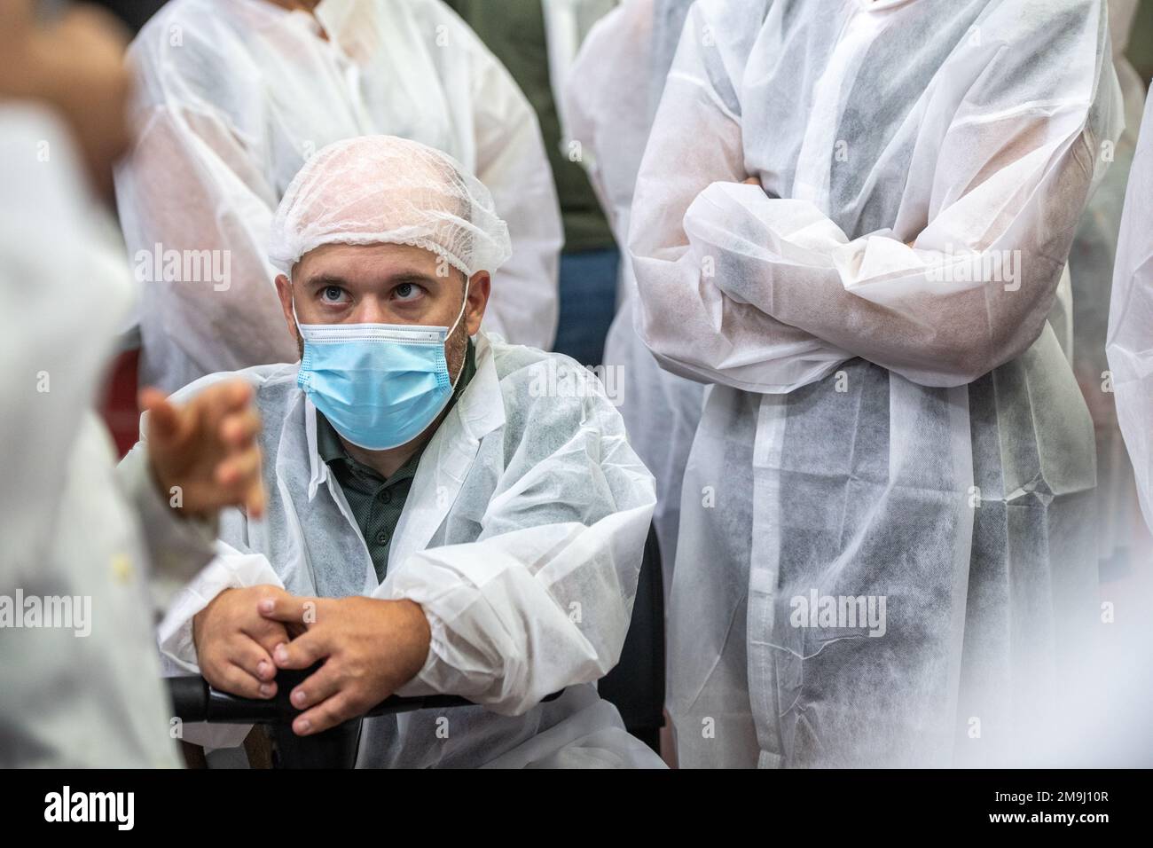 Personnes vêtues de vêtements de protection à l'usine de mise en conserve de poisson (USISA), Isla Cristina, Espagne Banque D'Images