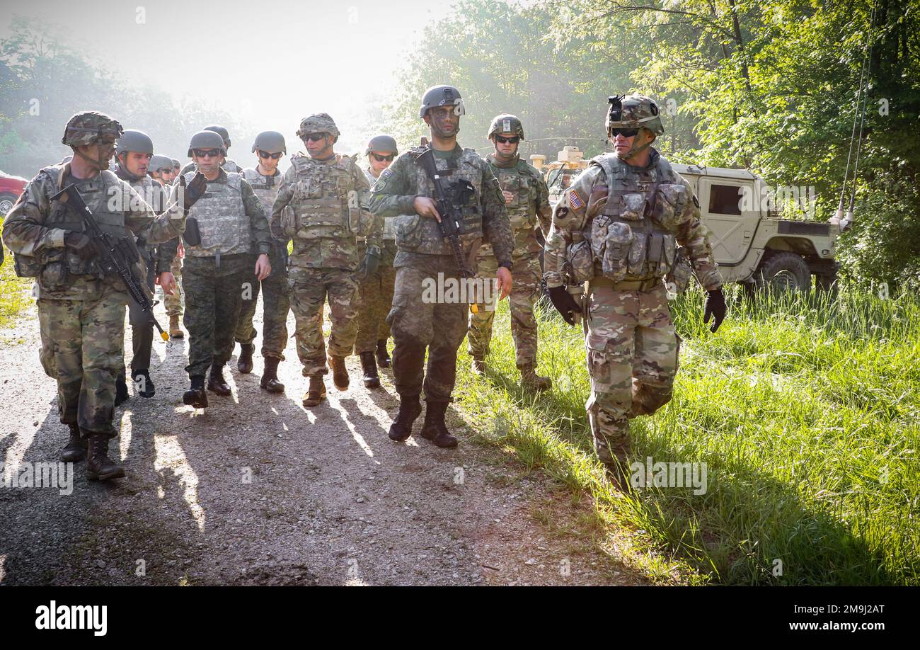 Des hauts dirigeants de la Garde nationale de l'Iowa et de la Force de sécurité du Kosovo, ainsi que des chefs du 1st Bataillon, 133rd Infantry Regiment, de la Garde nationale de l'armée de l'Iowa, marchent jusqu'à un site d'entraînement lors d'une visite des opérations au camp Atterbury, Indiana, sur 19 mai 2022. Environ 15 soldats de la KSF ont été intégrés à des compagnies dans l'infanterie 1-133rd au cours d'un exercice d'entraînement annuel de deux semaines. Les hauts dirigeants, dont l'adjudant général de l'IANG et commandant de la KSF, ont visité chaque compagnie vers la fin de l'exercice pour observer la pleine intégration des troupes de la KSF et reconnaître les soldats qui ont manifesté Banque D'Images