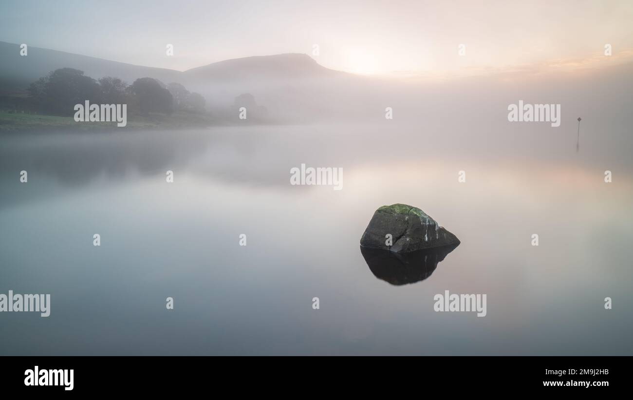 Une matinée calme et brumeuse sur le rivage du réservoir d'Embsay près de Skipton dans les Yorkshire Dales, avec Embsay Crag peeking au-dessus de la brume. Banque D'Images