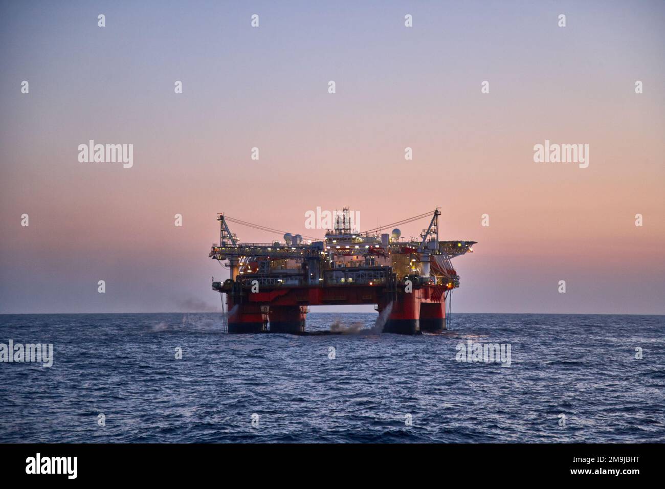 Beau paysage de coucher de soleil avec plate-forme semi submersible à l'arrière-plan. Banque D'Images