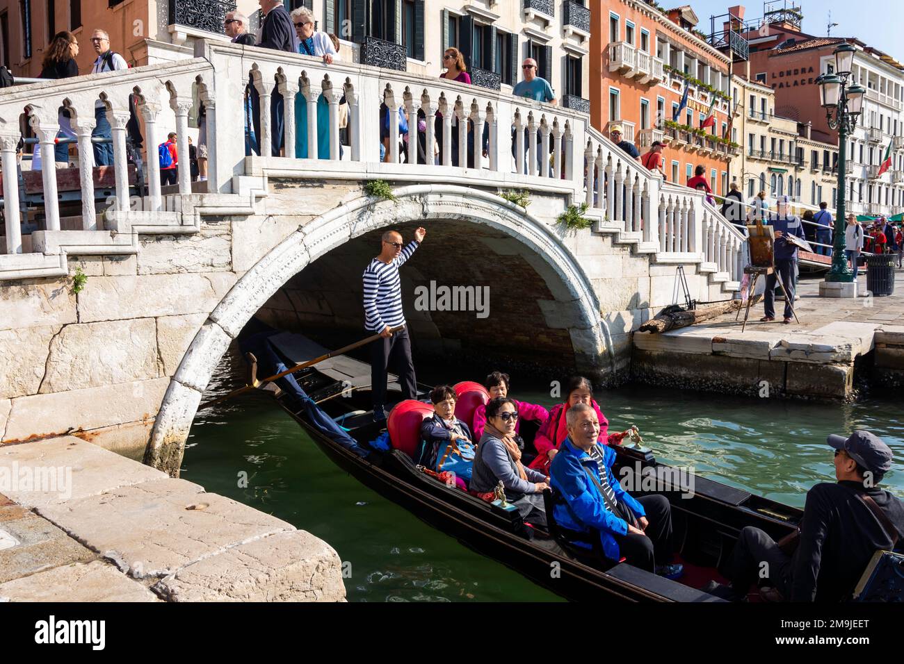 Une Gondola remplie de touristes passe sous la riva degli schiavoni à Venise, Italie. Banque D'Images