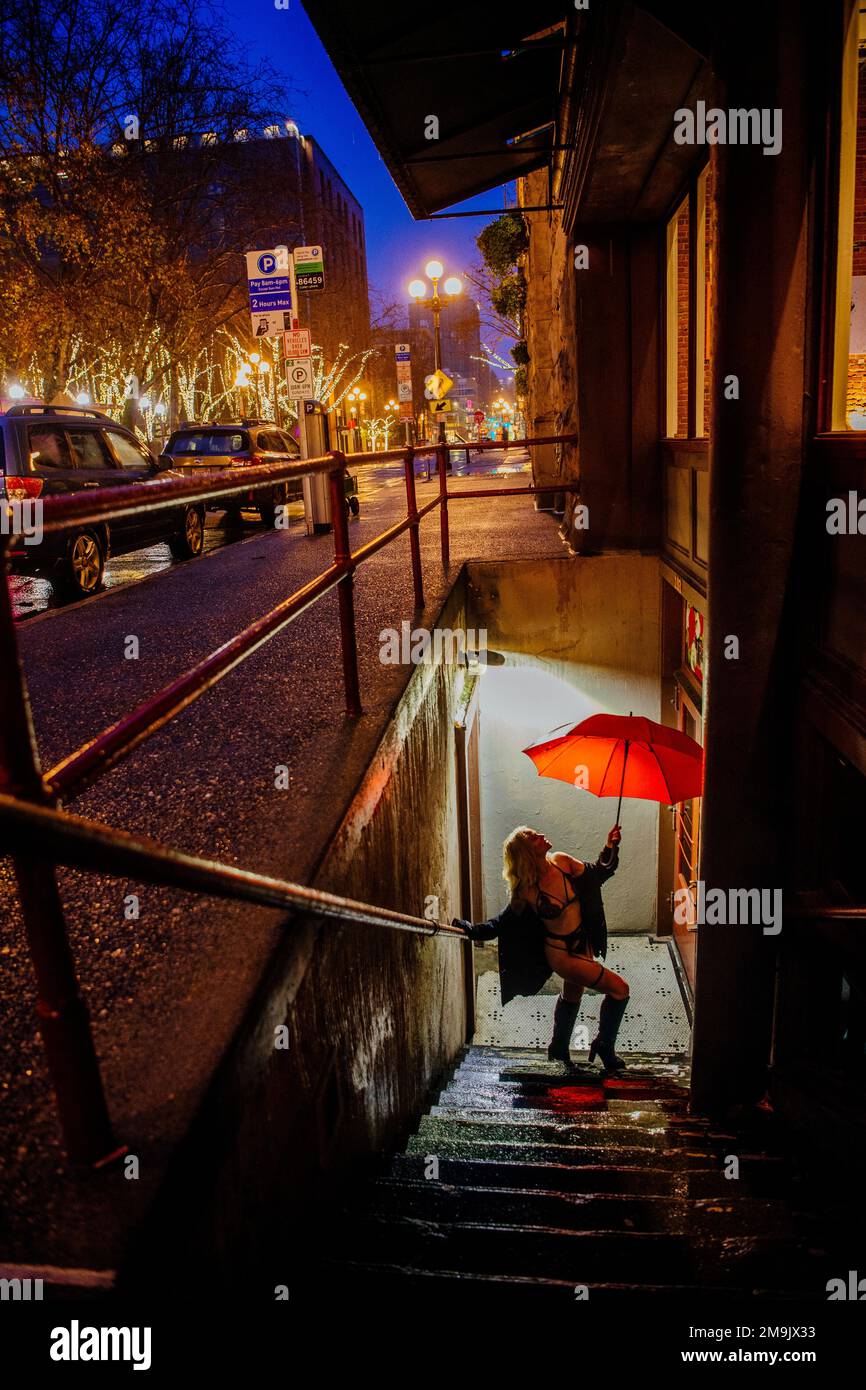 Femme avec parapluie dans l'escalier dans la ville la nuit, Seattle, Washington, Etats-Unis Banque D'Images
