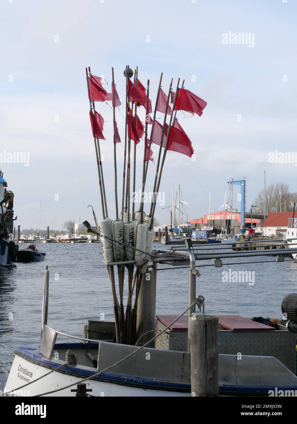 Drapeaux de marquage pour le piège à poisson d'un pêcheur sur un bateau de pêche dans le port de Burg, Fehmarn, Allemagne. Banque D'Images