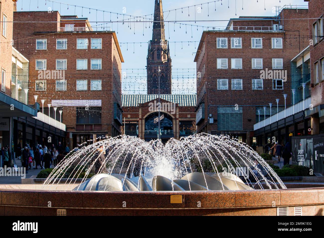 La fontaine de la pièce maîtresse de Smithford Way dans le centre de Coventry entre les quartiers supérieur et inférieur. L'ensemble de la zone a été rénové pour la ville de Culture 2021. La vue de la fontaine donne sur la partie supérieure du quartier vers la flèche de l'église de la Sainte Trinité au loin. Banque D'Images