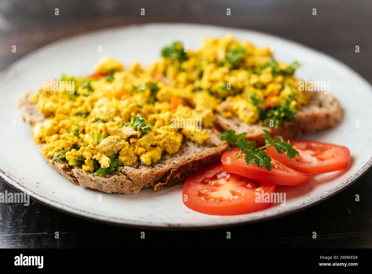 Tofu brouillés avec kale sur du pain à grains entiers. Banque D'Images