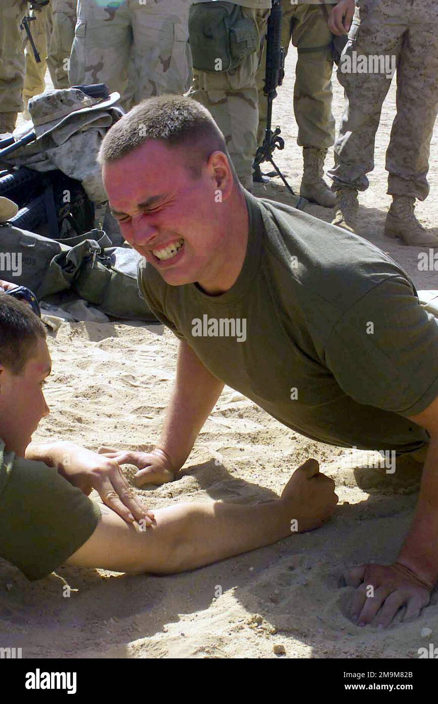 US Marine corps (USMC) Caporal lance (LCPL) Brad C. Distin, Charlie Company, 1st Bataillon, 5th Marines (1/5), équipe de combat régimentaire 5, 1st Marine Division, Camp Pendleton, Californie (CA), participe à la compétition de poussée lors de la rencontre sur le terrain de 1/5 au Camp Coyote, dans le nord du Koweït, au cours de l'opération ENDURING FREEDOM. Base: Camp Coyote pays: Koweït (KWT) Banque D'Images