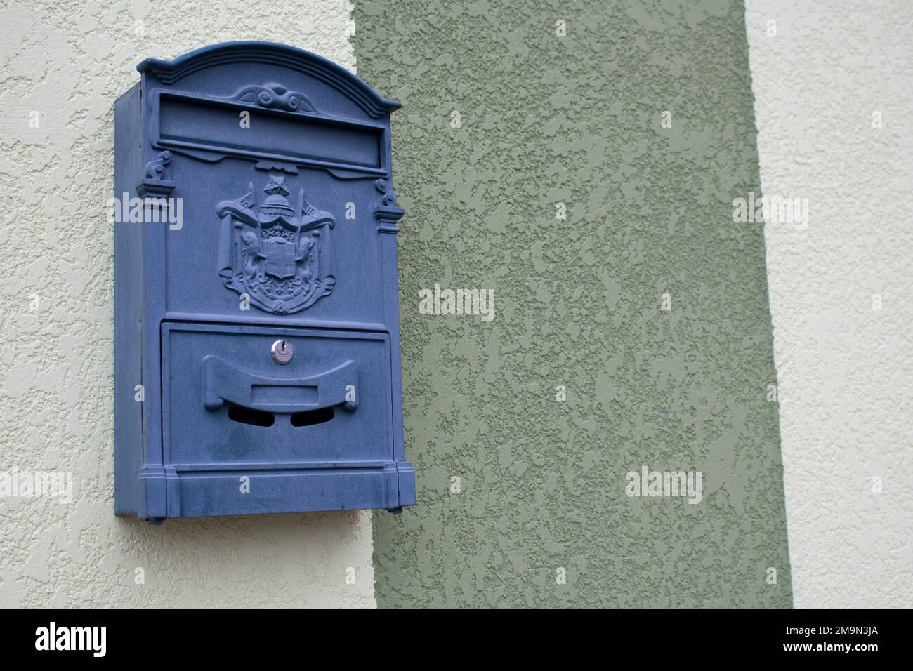 Une boîte aux lettres grise sur le mur d'un bâtiment sur l'une des rues de la ville. La boîte est verrouillée à l'aide d'une clé. Banque D'Images