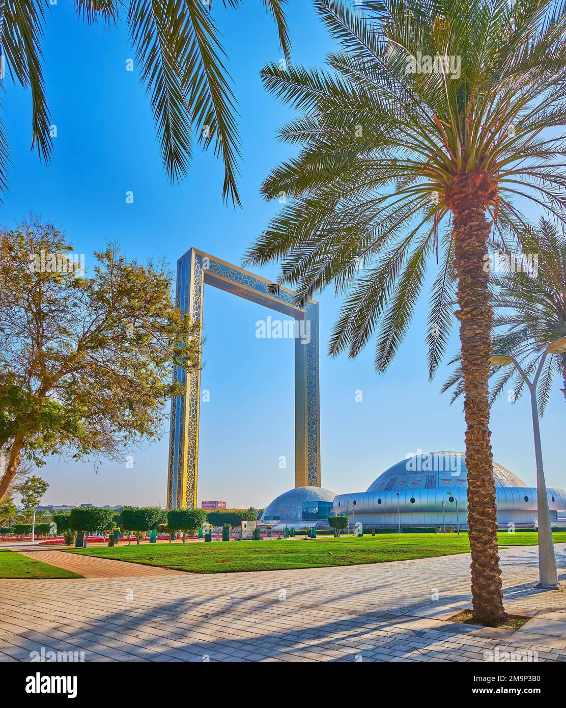 DUBAÏ, Émirats Arabes Unis - 6 MARS 2020 : palmiers luxuriants du parc Zabeel avec dômes du parc d'éducation Stargate et Dubaï Frame en arrière-plan, sur 6 mars à Dubaï Banque D'Images